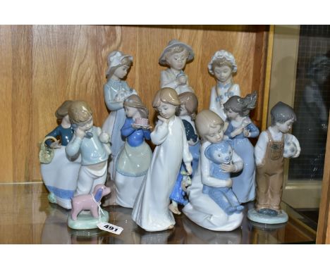 A GROUP OF ELEVEN NAO FIGURINES OF CHILDREN, to include a girl with puppy, a boy holding a telephone, a boy with a football, 