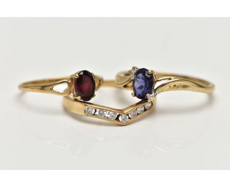 THREE 9CT GOLD GEM SET RINGS, the first designed with a four claw set, oval cut tanzanite, flanked with single cut diamond ac