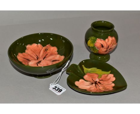 A MOORCOFT THREE PIECE SET,  comprising a small pedestal dish, diameter 14cm, a bud vase, height 9cm, a spade shaped trinket 