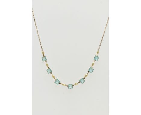 A MID 20TH CENTURY YELLOW METAL NECKLACE, set with seven pale blue square cut pastes, each claw set in a yellow metal mount, 