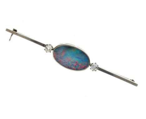 Black opal and diamond bar brooch, the oval flat opal 19mm long x 11.5mm, flanked to either side by old cuts totalling approx