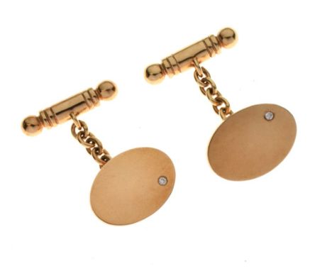 Pair of 9ct gold cufflinks, the plain oval panel set to one side with a small brilliant cut diamond, chain link connector to 