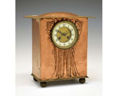 Arts &amp; Crafts/Art Nouveau copper mantel clock, with humped overhanging roof above repousse flowering plant design framing