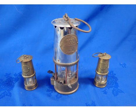 A MINER'S LAMP; 'THE PROTECTOR LAMP AND LIGHTING CO. LTD.' Eccles, and two miniature examples