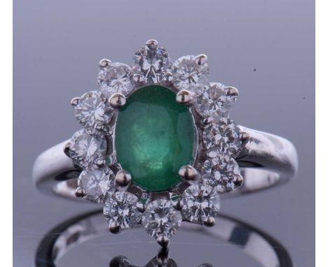 Emerald and diamond cluster ring, the oval faceted cut emerald within a small brilliant cut diamond surround, 1ct approx, sta