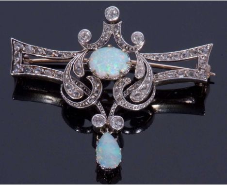 Opal and diamond set brooch centring a cabochon opal within an openwork scroll design set with graduated small old cut diamon