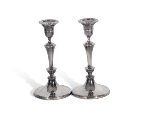 A pair of Edward Vll silver candle sticks, each with a ring turned tapered stem to a spreading circular loaded base, with det