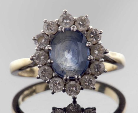 18ct gold sapphire and diamond cluster ring, the oval faceted pale sapphire set within a small diamond surround, total 0.75ct