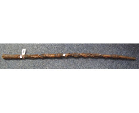 Eastern carved and moulded wooden walking stick decorated with snakes, fishes heads and flower heads (possibly Japanese).(B.P