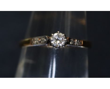 An 18ct gold and diamond solitaire ring with diamond set shoulders. 1.9g approx. (B.P. 24% incl. VAT)