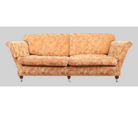 A modern three seat sofa, possibly by Duresta, with red and beige damask upholstery, raised on mahogany bun feet and castors,