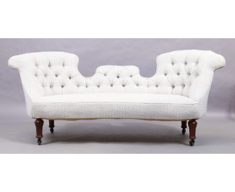 A Victorian mahogany framed double back salon sofa, last quarter 19th century, recently upholstered in a cream and grey butto