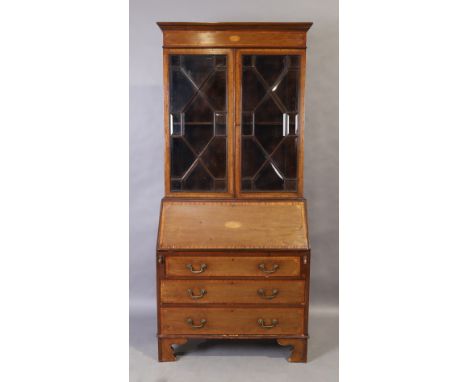 An Edwardian Sheraton revival mahogany bureau bookcase, the inlaid cornice above two astragal glazed doors with bevelled glas