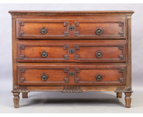 A French oak commode, first quarter 19th century, with three carved drawers and reeded columns, raised on square tapering fee