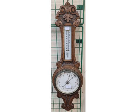 An early 20th century carved oak aneroid barometer 