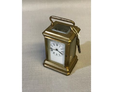 Small Victorian brass carriage clock with key, running condition. Measures 9x5x4.5cm height with handle up. 