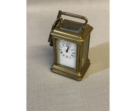 Small Victorian brass carriage clock with key, running condition. Measures 9x5x4.5cm height with handle up. 