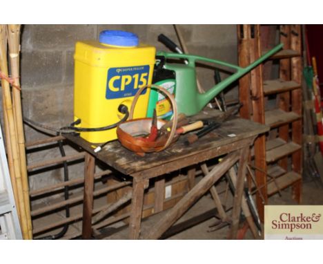 A potting table; and a quantity of various hand tools; knapsack sprayer; long handled gardening tools etc. 
