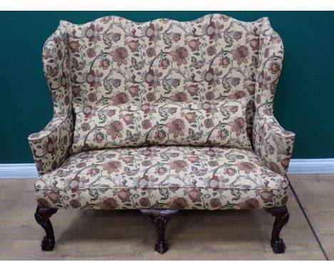 A George II style treble humpback Winged Sofa with cream floral upholstery mounted upon three shell carved cabriole front sup