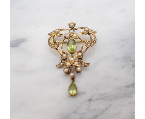 An Edwardian Peridot and Seed Pearl Pendant/Brooch millegrain-set oval-cut peridot within scrolled openwork plaque set seed p