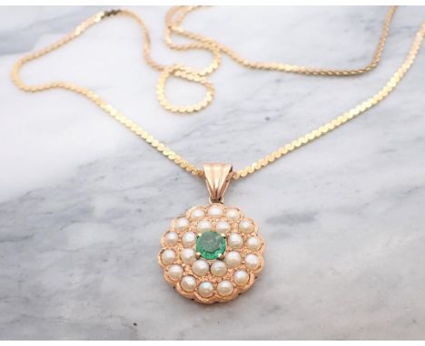 An Emerald and Cultured Pearl Pendant claw-set round emerald within double frame of half pearls in 14ct rose gold on fine 'S'