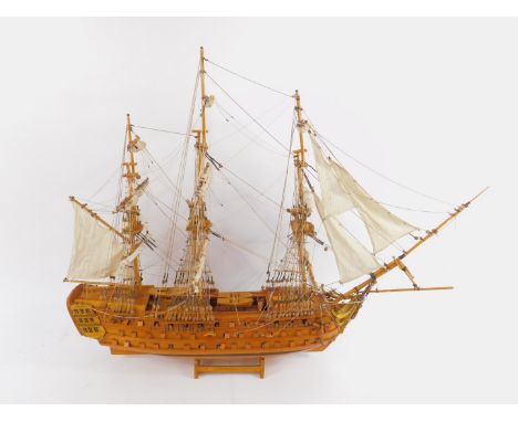 A wooden scale model of an 18thC Man O War, fully rigged with sails, on a wooden stand, 106cm long.