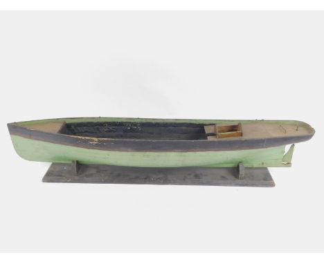 A wooden scale model of a Victorian ship hull, raised on a wooden base, 106cm long.