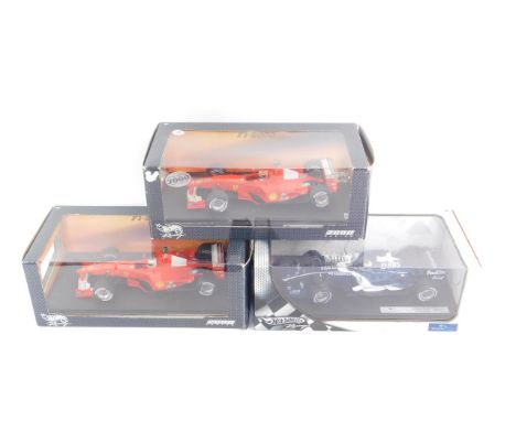 Three Hotwheels model racing cars, scale 1:18, comprising Williams F1 Team FW28 Nico Rosberg; Ferrari F1-2000, Michael Schuma