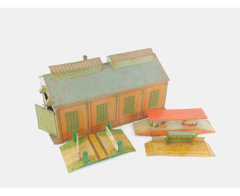 A Hornby OO-gauge tin plate engine shed, 46cm L, together with a Scarborough platform waiting shelter, level crossing, and Br