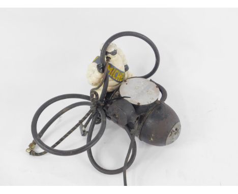 A mid 20thC Michelin air compressor, having stylised metal figure of Mr Bibendum, with Michelin sash, sat astride an artiller
