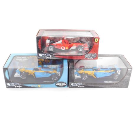 Three Hotwheels racing cars, scale 1:18, comprising Michael Schumacher in a Ferrari 2002 World Champion, limited edition; Ren