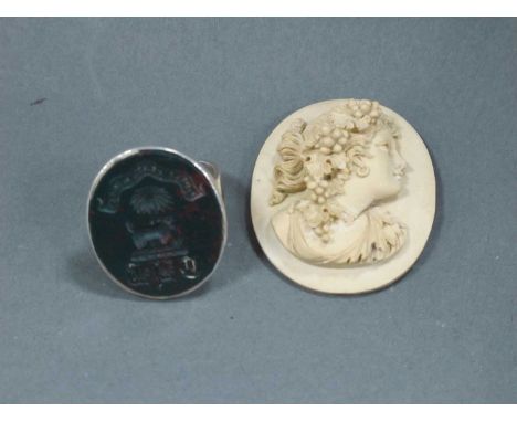 A Mid XIX Century Lava Brooch, carved with a head and shoulders bust of a lady, and a white metal ring with hardstone seal in