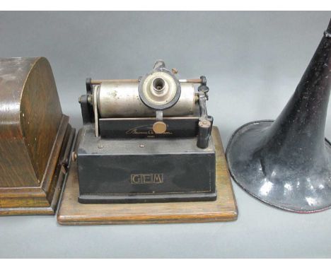 An Edison Gem Phonograph, in oak case, with horn.1. HORN HAS 3CM CRACK AND IS VERY PITTED AND DENTED. 2. COVER NEW PIECE OF W