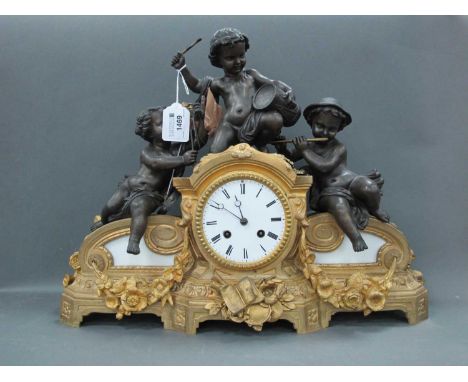 A Late XIX Century Gilt Metal Mantle Clock, the top surmounted with three speltre cherubs, each playing musical instruments, 
