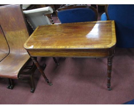 An Early XIX Century Mahogany Card Table, with crossbanded fold-over top and baized interior on turned legs, 73cm high, 90cm 