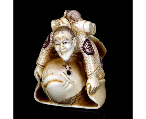 A Japanese carved ivory netsuke in the form of a man with a fish, signed, height 4cm 