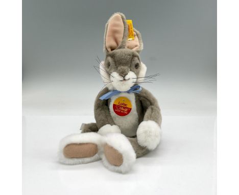 Grey and white stuffed seated rabbit. Includes original box, 9"L x 6"W x 4"H. Steiff tag attached. Dimensions: 8"L x 6.5"W x 