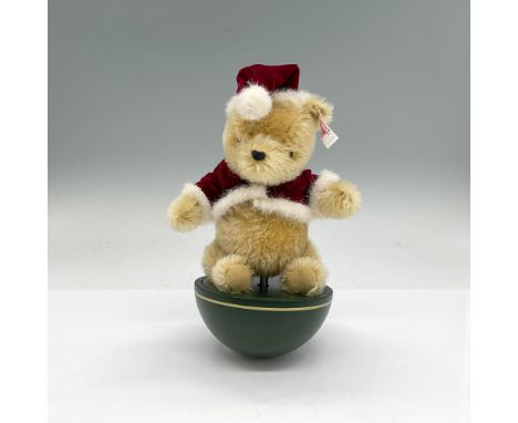 Tan bear in a Santa hat and shirt sitting on a half wooden ball base. Includes Certificate of Authenticity and original box, 