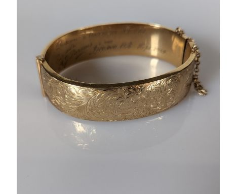 A 9ct yellow gold bangle with etched decoration, wax filled, hallmarked for Deakin &amp; Francis Ltd., Birmingham, 1969, 65 x