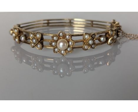 An Edwardian-style yellow gold hinge bangle with pearl decoration and etched design, 60mm, unmarked but tests for 14ct gold, 