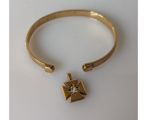A yellow gold torc bangle, 55mm, unmarked but tests for 9ct, 15.2g and a gold pendant with diamond decoration, unmarked but t