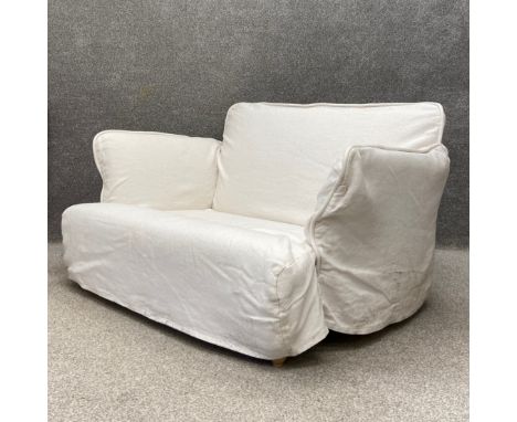 A contemporary Maker &amp; Son Otter range two seater sofa having a shaped back with flared arms over a deep seat with button
