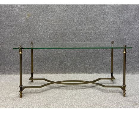 A 20th century Hollywood Regency style coffee table having a rectangular plate glass top raised on fluted brass Neoclassical 
