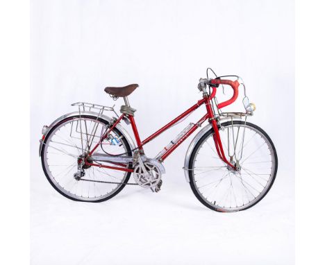 Collectible antique electric red bicycle features a company sticker on the dynamo light generator by Matsushita, now known as