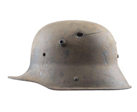 A GERMAN MODEL 1916 STAHLHEM, CIRCA 1916-18 pierced by a bullet through the brow and exiting at the back 17 cm; 6 3/4 in high