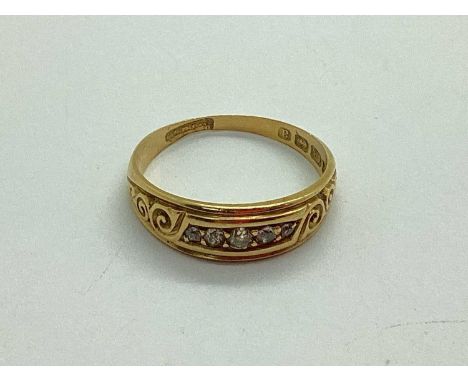 An 18ct Gold Victorian Style Ring, graduated inset highlights, within decorative border and scrolling shoulders (finger size 