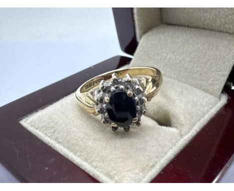 A 9ct Gold Stone Set Cluster Ring, of flowerhead design, the oval claw set centre stone set within illusion set diamond surro