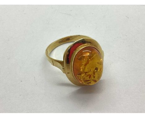 An Amber Coloured Stone Set Modernist Style Ring, the oval cabochon stone, collet set within modernist style surround, to uni