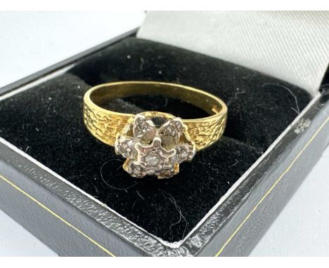 An 18ct Gold Diamond Cluster Ring, the brilliant cut diamonds illusion set within flowerhead cluster style setting, between t