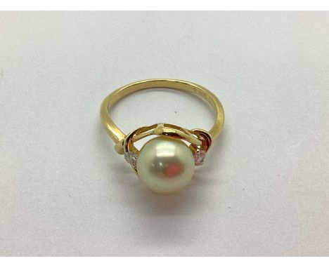 A Modern Freshwater Pearl and Diamond Set Dress Ring, the pearl bead set within knotted style setting, to diamond set shoulde